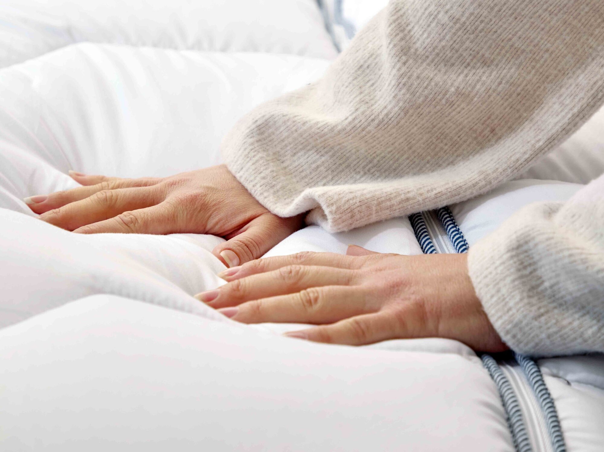 persoon liggend op bank met dekbed over zich heen